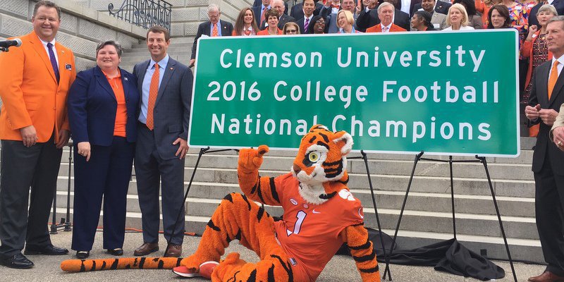 Swinney poses with one of the new signs honoring the National Championship  (Photo by Jared Rogers-Martin)