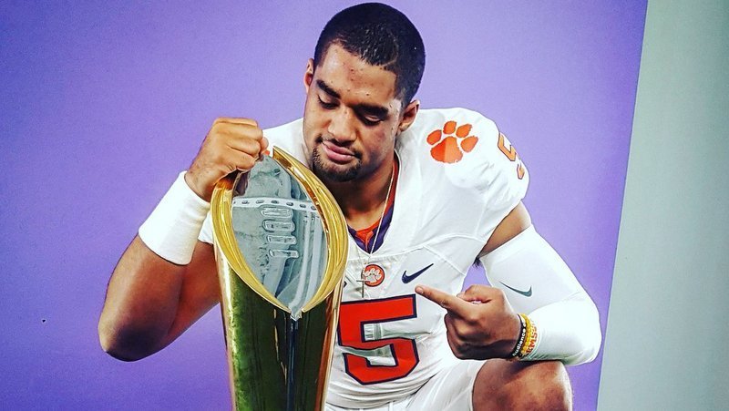 Uiagalele iposes with Clemson's National Championship trophy 
