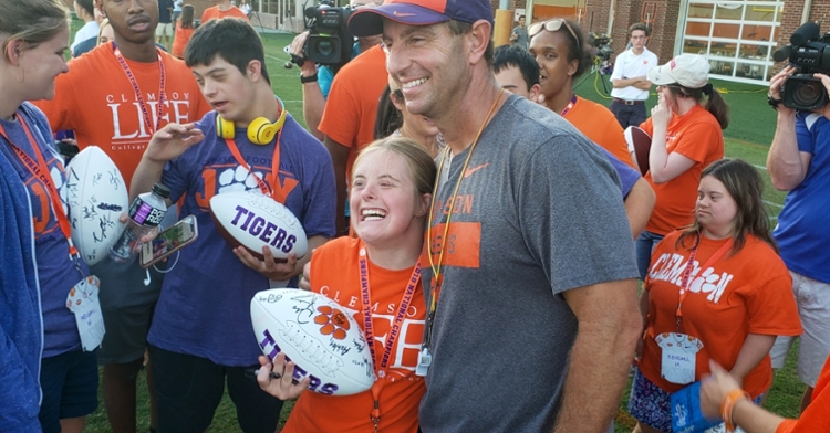 Dabo Swinney poses with a student after practice Wednesday. 