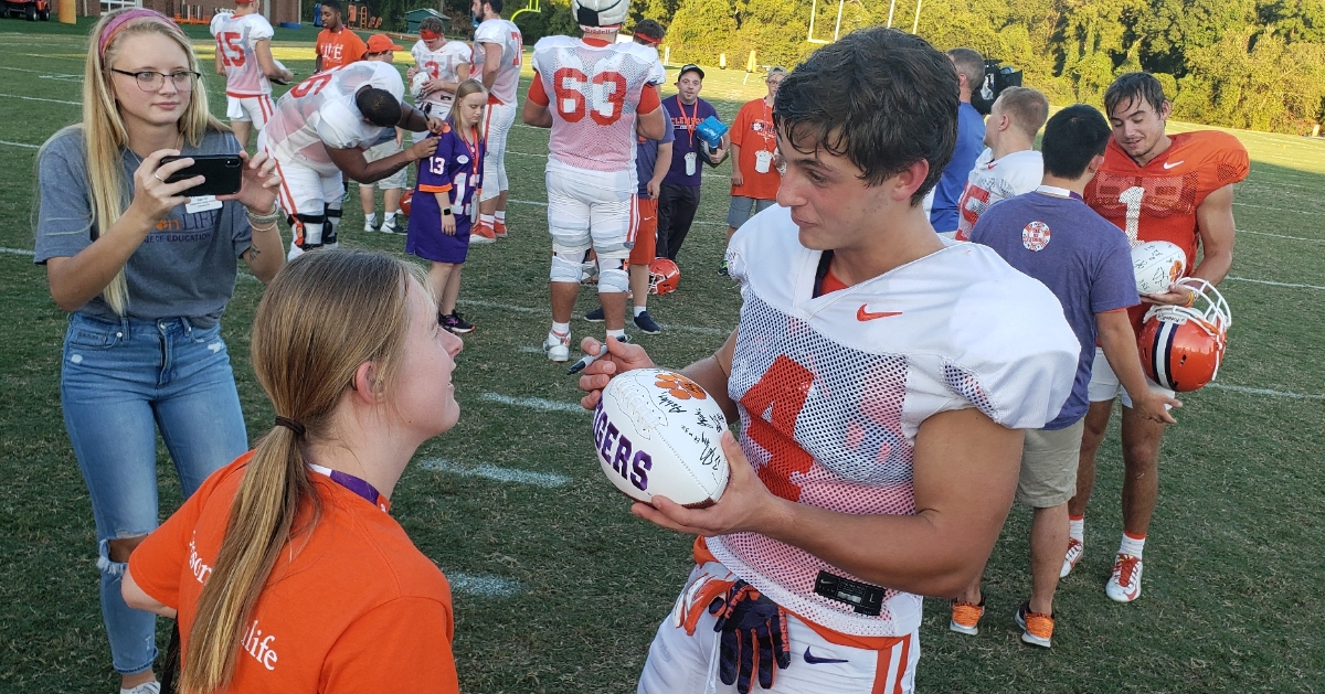 Dabo Swinney poses with a student after practice Wednesday. 