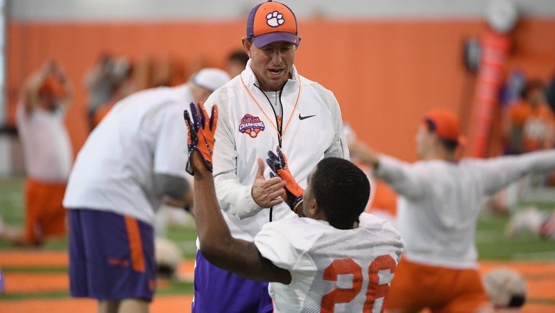 Swinney talks to a player before the start of Monday's practice 