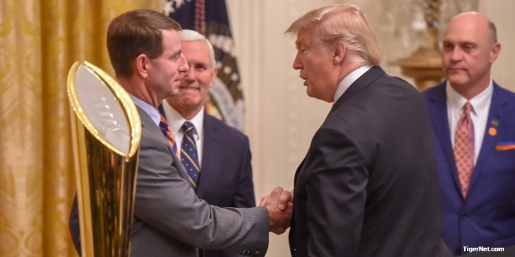 Swinney (left) shakes the hand of President Donald Trump 