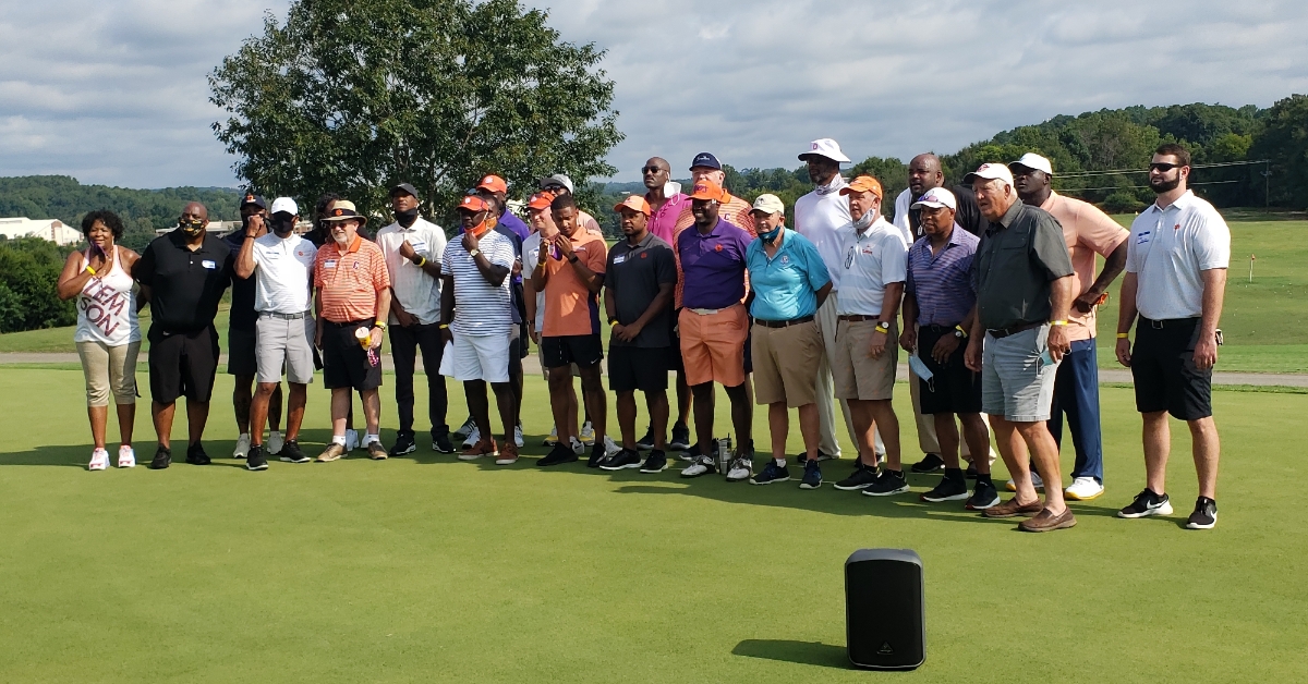 The celebrity cast at the golf tournament poses for a picture. 